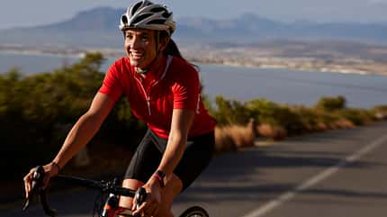 Female cyclist going uphill on roadbike & laughing