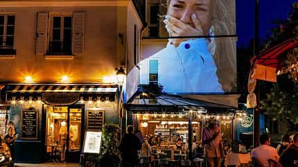 PARIS, FRANCE - JULY 28: A photograph of Gold medalist Pauline Ferrand Prevot of Team France reacting on the podium during the Women’s Cross-Country Cycling Mountain Bike Gold Medal race at Elancourt Hill in Elancourt, France, is projected as part of Parisienne Projections in Montmartre on July 28, 2024 in Paris, France. Parisienne Projections displays the heroics and tragedies of 16 days of Olympic competition throughout the host city of Paris. (Photo by Carmen Mandato/Getty Images Europe) PARIS, FRANCE - JULY 28: A photograph of Gold medalist Pauline Ferrand Prevot of Team France reacting on the podium during the Women’s Cross-Country Cycling Mountain Bike Gold Medal race at Elancourt Hill in Elancourt, France, is projected as part of Parisienne Projections in Montmartre on July 28, 2024 in Paris, France. Parisienne Projections displays the heroics and tragedies of 16 days of Olympic competition throughout the host city of Paris. (Photo by Carmen Mandato/Getty Images Europe)