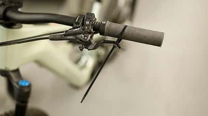 Mountainbike,Fahrrad,Ratgeber,Bike Hack,Bikehack,Hack,Tricks,Tipps,DIY, selbstgemacht,Kabelbinder,Bremse,Bremshebel,Entlüften,einfach Entlüften,schnell Entlüften,Bleeding,Shimano,Sram,Enduro,Trickstuff,schwammig Der Bremshebel einer Mountainbike-Scheibenbremse wird mit einem Kabelbinder zum Lenker gezogen. Das hilft beim Entlüften. Das geht so manchmal sogar ohne Werkzeug.