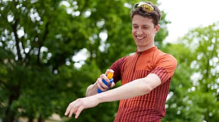 Radsportler cremt sich mit Sonnenschutz ein Radsportler cremt sich mit Sonnenschutz ein