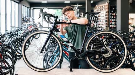 young man checking out at new bicycle in bikeshop young man checking out at new bicycle in bikeshop
