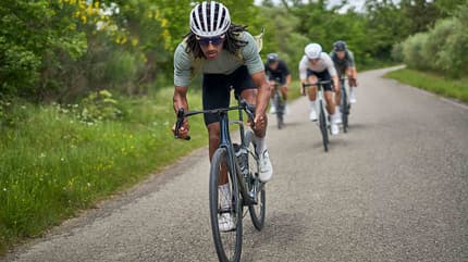 Radfahren, Peloton, Führung, Asphalt, Team, uvex Ein Rennradfahrer übernimmt die Führungsarbeit vor dem restlichen Team auf einem asphaltierten Weg im Grünen.