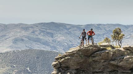 Male mountainbikers posing on a cliff at Andalucian Sierra Nevada, Spain. Male mountainbikers posing on a cliff at Andalucian Sierra Nevada, Spain.