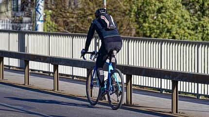 Rear view of man on racing bicycle at Swiss capital city.