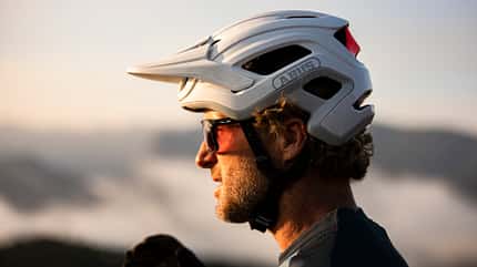 Mann mit weißem Mountainbike-Helm im Seitenprofil. Mann mit weißem Mountainbike-Helm im Seitenprofil.