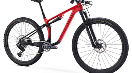 Das Bild zeigt ein vollgefedertes Mountainbike des Modells VTT RR RACE 940S in roter Lackierung, freigestellt vor weißem Hintergrund. Das Fahrrad verfügt über eine moderne Rahmengeometrie, Scheibenbremsen und eine hochwertige Kettenschaltung.