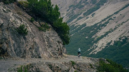 Löffler Gravel Kollektion 2026 SKYS,Actionfoto,weite Ansicht Berge,Abfahrt mit dem Gravelbike