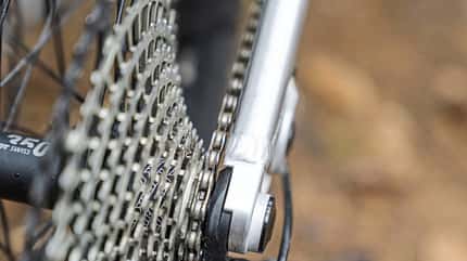 Detailaufnahme eines Mountainbike-Hinterbaus mit Fokus auf Kassette, Kette und Ausfallende. Die Aufnahme zeigt die Schaltkomponenten und den Rahmenanschluss im Bereich des Hinterrads. Zu erkennen ist eine DT Swiss 350 Nabe.
