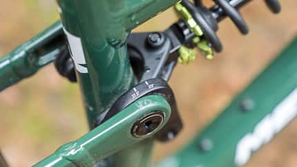 Detailaufnahme eines Mountainbike-Hinterbaus mit einstellbarem Dämpfer und Umlenkhebel. Die Einstellung für 27,5- und 29-Zoll-Laufräder ist sichtbar.