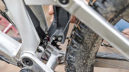 Mountainbike, MTB Beerfelden, Hinterbau, Aluminiumrahmen, Dämpfer, Schutzabdeckung, Federung, Mountainbike-Technik, Offroad, Fahrradkomponente Detailaufnahme eines Mountainbike-Hinterbaus mit Aluminiumrahmen, Dämpfer und Schutzabdeckung am Hinterrad. Die Aufnahme entstand vermutlich beim MTB-Event in Beerfelden.