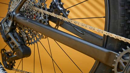 Bike Ahead The Frame, Fahrradrahmen, Carbonrahmen, Kettenstrebe, Schaltwerk, Mountainbike, Antrieb, Kassette, Fahrradtechnik, Detailaufnahme Detailaufnahme des Hinterbaus und Antriebs eines Bike Ahead The Frame Fahrrads, Fokus auf Kettenstrebe, Schaltwerk und Kassette.