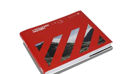 Gebundenes Buch mit rotem Cover, Aufschrift 'R 30 YR', diagonalen Aussparungen mit Landschaftsfoto und Rotwild-Logo.