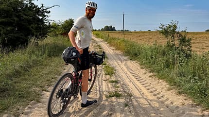 Jonas Deichmann und Josefine Rutkowski auf Tour Around Europe, Woche 15, Jonas im Sand Jonas Deichmann und Josefine Rutkowski auf Tour Around Europe, Woche 15, Jonas im Sand