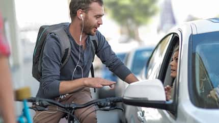 Ein Radfahrer und eine Autofahrerin diskutieren. 