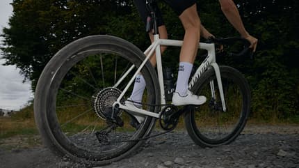 Fahrer auf einem Specialized Gravelbike mit Leeze Carbon Laufrädern fährt über losen Schotter.