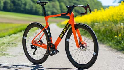 Das Storck Fascenario.5 in Orange mit Carbon-Laufrädern, freistehend auf einem Feldweg. Das Storck Fascenario.5 in Orange mit Carbon-Laufrädern, freistehend auf einem Feldweg.