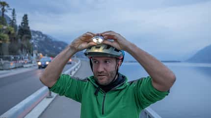 Cyclist adjusts headlamp on his helmet, Outdoor fitness at night Cyclist adjusts headlamp on his helmet, Outdoor fitness at night