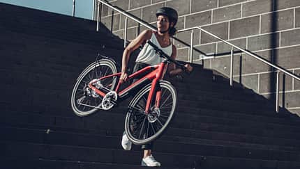 Frau trägt leichtes E-Bike Treppenstufen herab Frau trägt leichtes E-Bike Treppenstufen herab