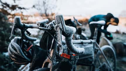 Vertical shot of a bicycle and a helmet covered with snow during winter frost