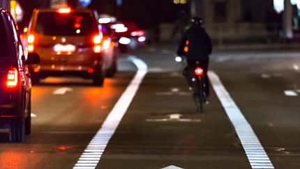 Cyclist drives on the bike path past the traffic jam