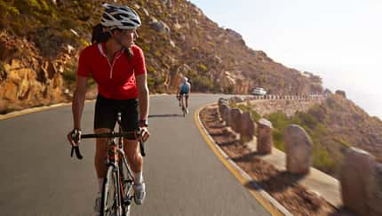 Female pro cyclist taking lead on mountain climb