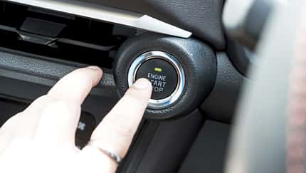 Owner finger to touching and press button function start and stop car engine in the automobile.