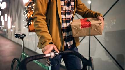 An unrecognizable delivery guy delivering Christmas gifts and orders
