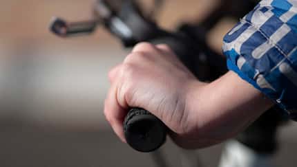Close up view of a teenagers hand on the bicycle handlebars