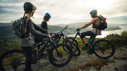 Group of friends mountainbike riders: MTB biking outdoor up mountain of Norway