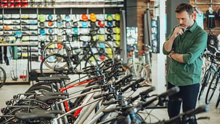 man checking out bicycles in bike shop