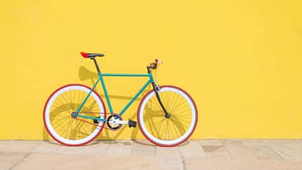 Buntes Fahrrad vor knallgelber Wand 