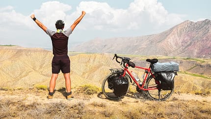 Radfahrer jubelt in Wüste 