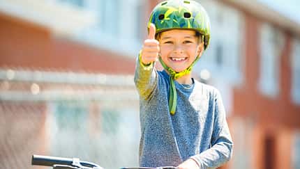 child having fun outdoors driving bike for children on playground