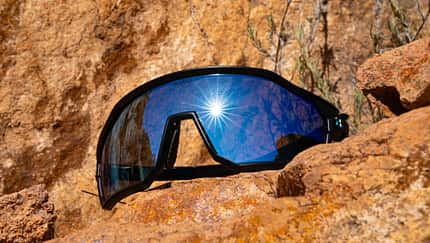 SunGod Velans Matte Black,Sonnenbrille,Radbrille,schräge Ansicht auf Felsen