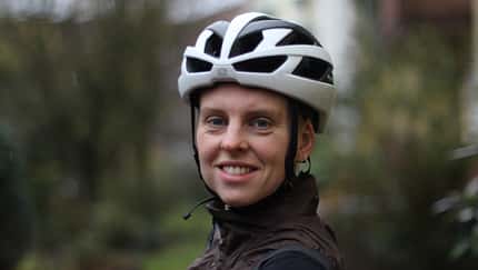 Portrait einer Radfahrerin, die den Rudy Rebel Helm trägt. 