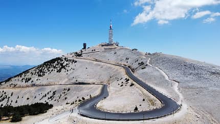 Schmale Autobahn, die zum Mont Ventoux in Frankreich führt, mit blauem Himmel im Hintergrund. Schmale Autobahn, die zum Mont Ventoux in Frankreich führt, mit blauem Himmel im Hintergrund.