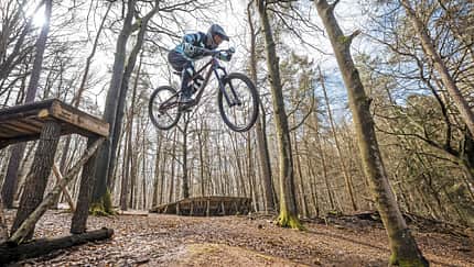MTB, Mountainbike, Beerfelden, Sprung, Downhill, Bikepark, Wald, Fahrradtechnik, Action, 2024 Mountainbiker springt mit einem MTB über einen Holzsprung im Wald, aufgenommen in Beerfelden.