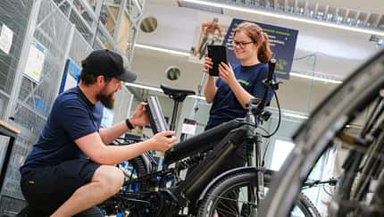 Zwei Mitarbeitende von Rebike in der Werkstatt. Zwei Mitarbeitende von Rebike in der Werkstatt.