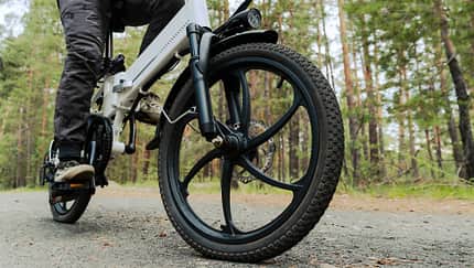 Radfahrer fährt auf einem Radweg im Wald. Fahren mit einem modernen Elektrofahrrad. Radfahrer fährt auf einem Radweg im Wald. Fahren mit einem modernen Elektrofahrrad.