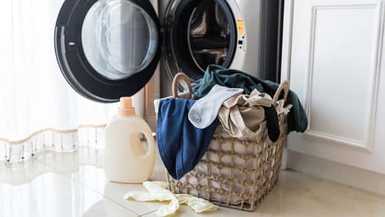 Basket with laundry and washing machine