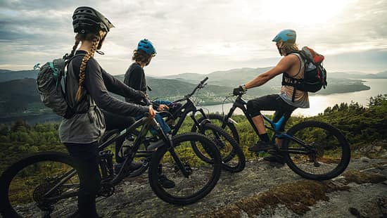 Group of friends mountainbike riders: MTB biking outdoor up mountain of Norway