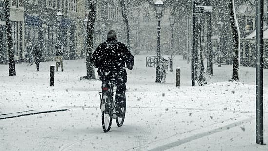 Ein Biker wagt es, mit dem Fahrrad auf dem frischen Schnee zu fahren.
