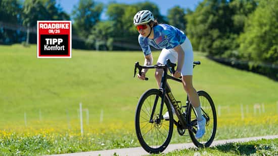 Radfahrerin im sportlichen Antritt auf der BMC Roadmachine mit Komfort Testsiegel von ROADBIKE.