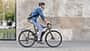 Mann pendelt mit seinem E-Bike zur Arbeit