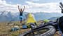 Woman bikepacking and camping, she set up her tent on top of the mountains, arms up