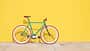 Buntes Fahrrad vor knallgelber Wand 
