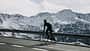 Andorra, cyclist on mountain road with snowy mountains in the background
