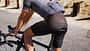 Midsection of man cycling on road