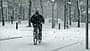 Ein Biker wagt es, mit dem Fahrrad auf dem frischen Schnee zu fahren.
