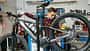 Fahrradmechaniker prüft die hintere Schaltung und die Bremsen eines Mountainbikes. Fahrradmechaniker prüft die hintere Schaltung und die Bremsen eines Mountainbikes.